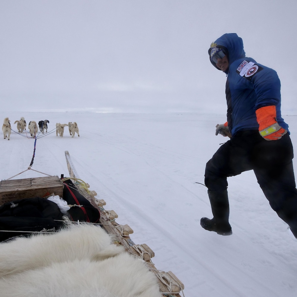 Devon Manik court à côté de son traîneau à chien, au mois de juin près de Resolute Bay, dans le nord du Nunavut.