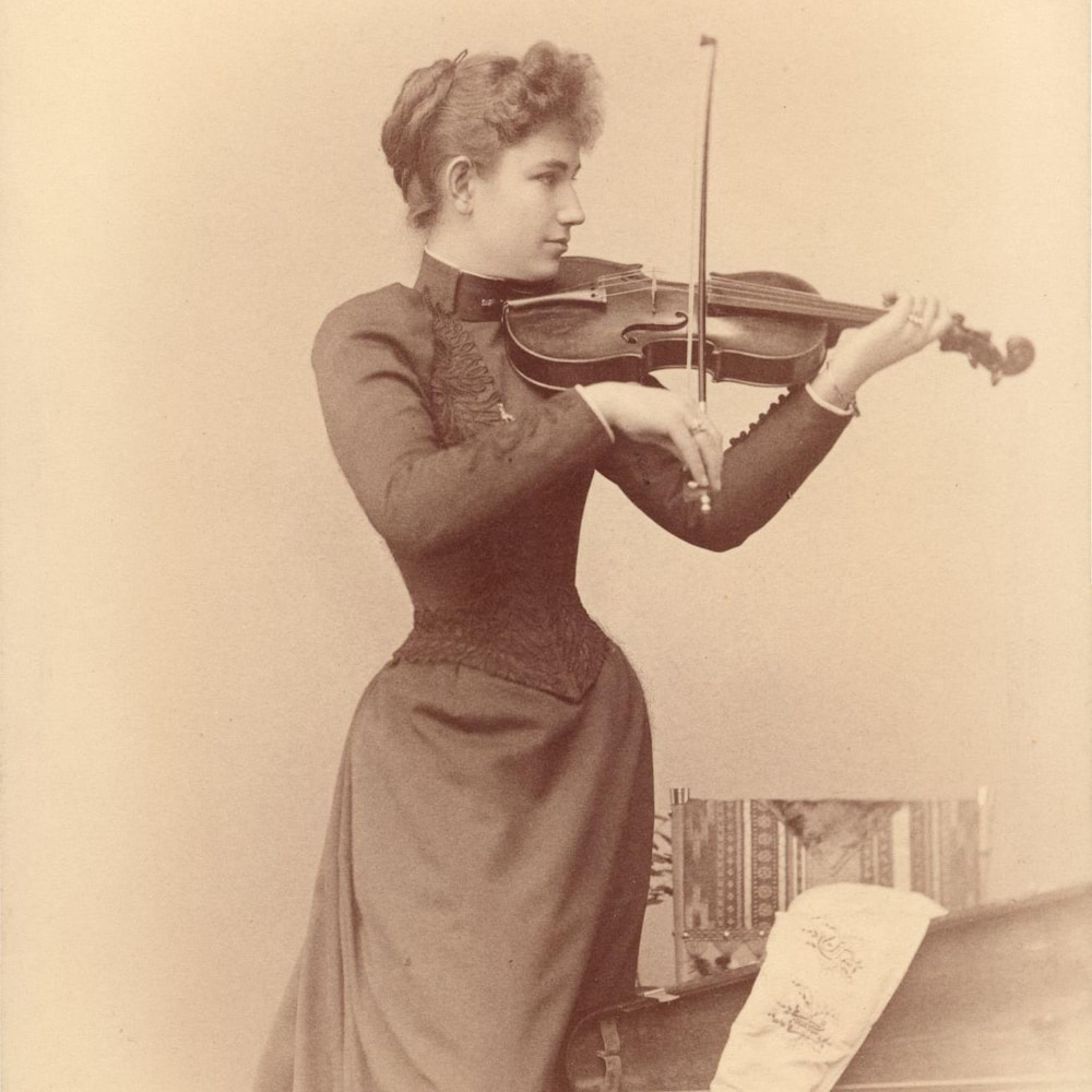 Photo en noir et blanc d'une femme et de son violon.