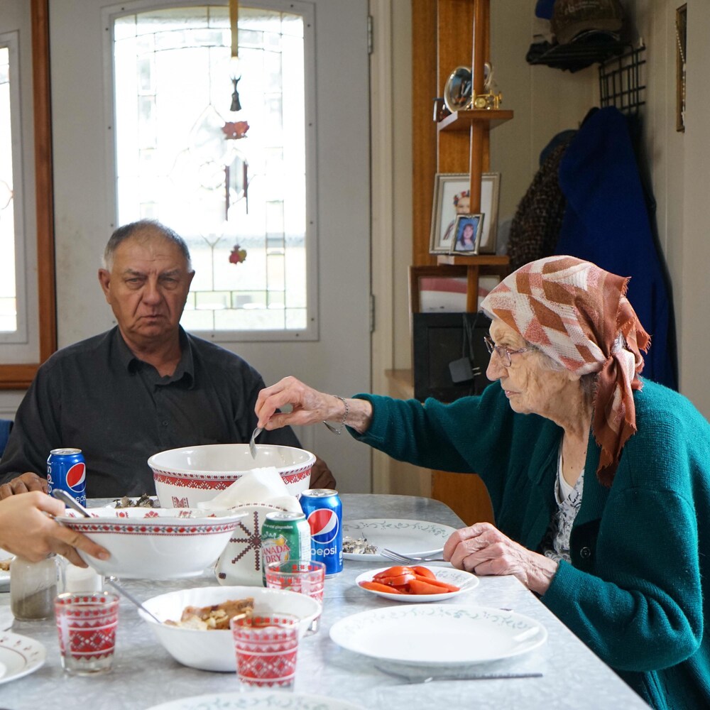 Trois personnes qui mangent autour d'une table