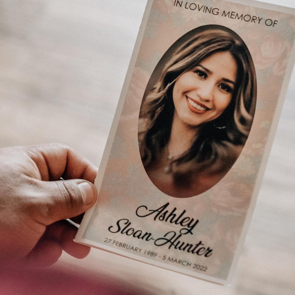 Colten tient dans sa main une carte en mémoire de Ashley Sloan, sa femme avec un portrait d'elle.