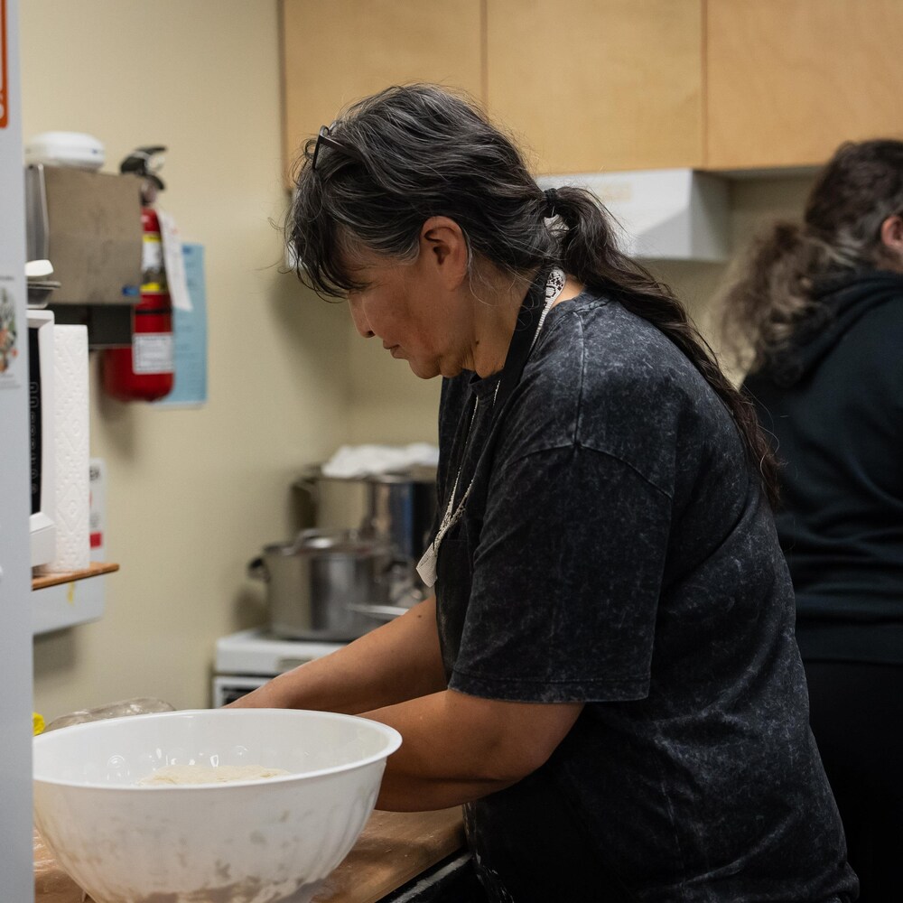 Viola Papequash en train de faire la cuisine, à Whitehorse, au Yukon, hiver 2024, 2025.