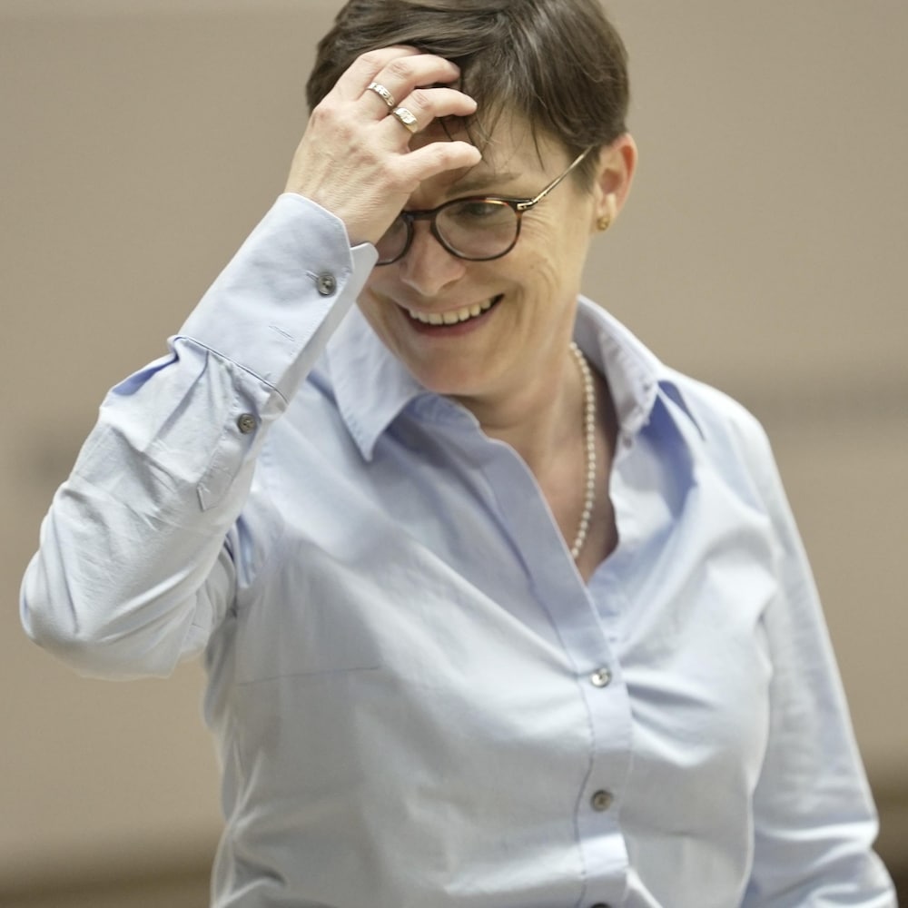 Aurélie Lacassagne passe une main   dans ses cheveux en souriant.