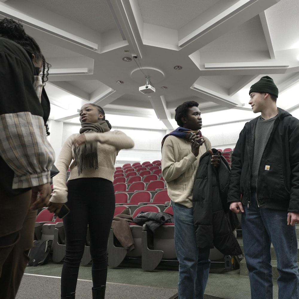 Six personnes discutent dans une salle de projection de l'Université de Hearst.
