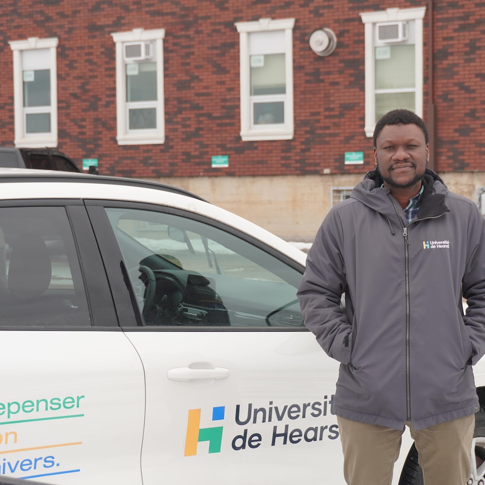 Papa Ibrahima Coulibaly près d'une voiture de l'Université de Hearst.