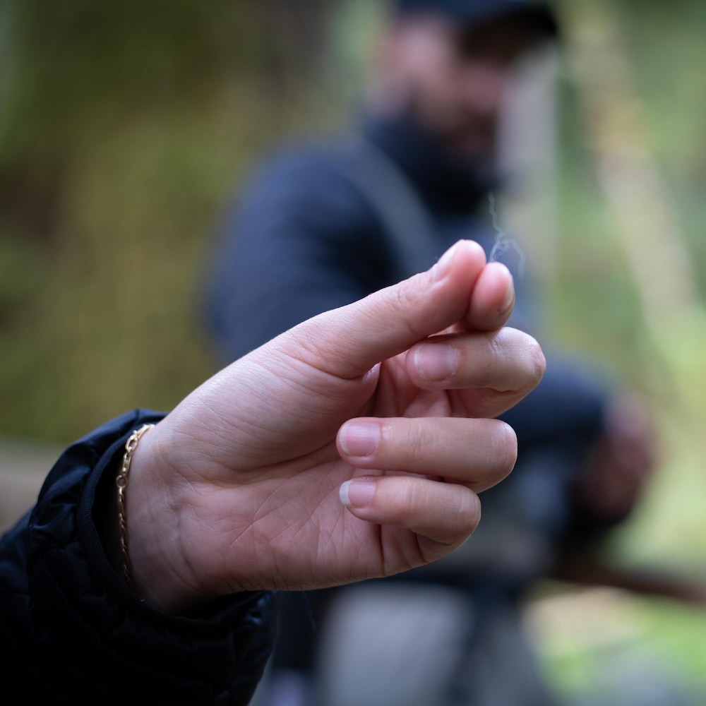 Une main tient un poil entre ces doigts, près de Klemtu, en Colombie-Britannique, en octobre 2023.