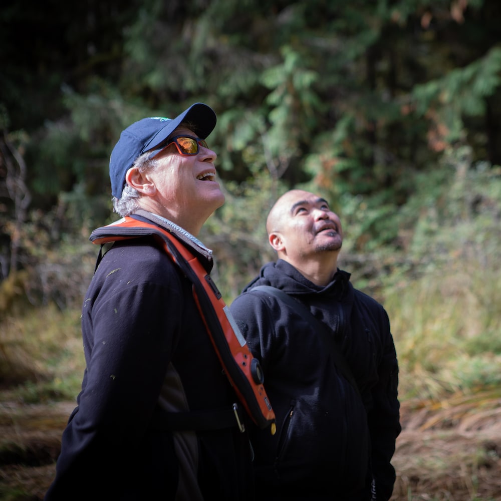 George Heyman et Doug regardent vers l’off, dans une forêt près de Klemtu, en Colombie-Britannique, en octobre 2023.