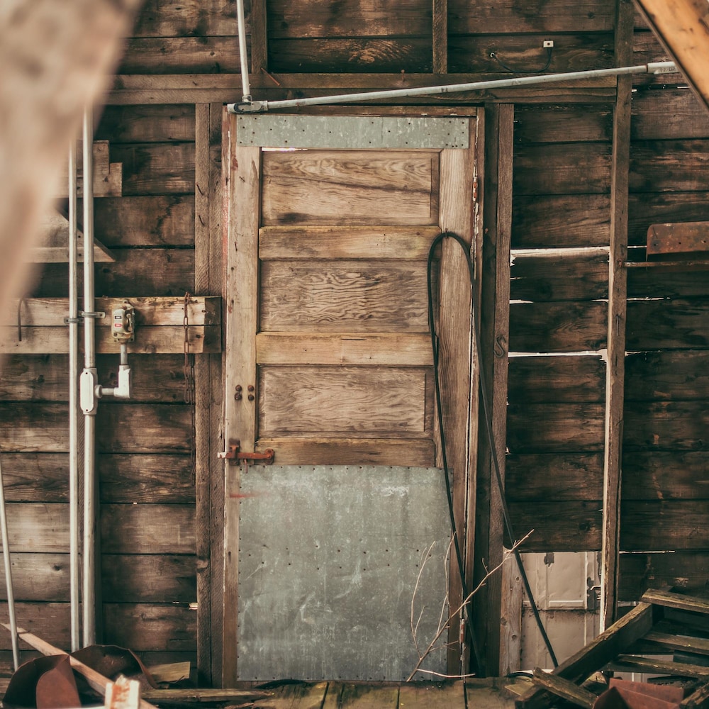 Un mur en bois avec une porte à l'intérieur d'un vieil élévateur en bois, avec des débris de bois, à Barnsley au Manitoba, début juin 2022.