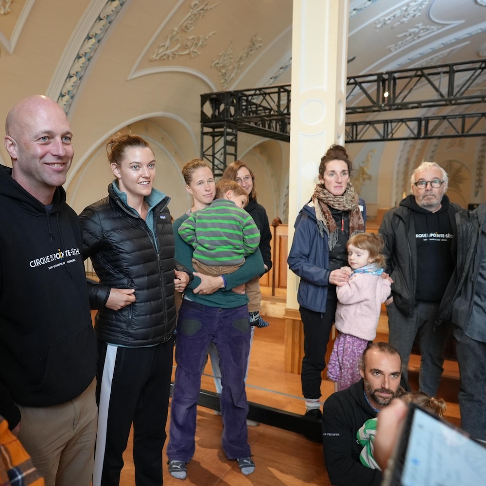 Un groupe d'adultes réuni à l'intérieur d'une église écoute des conseils. 