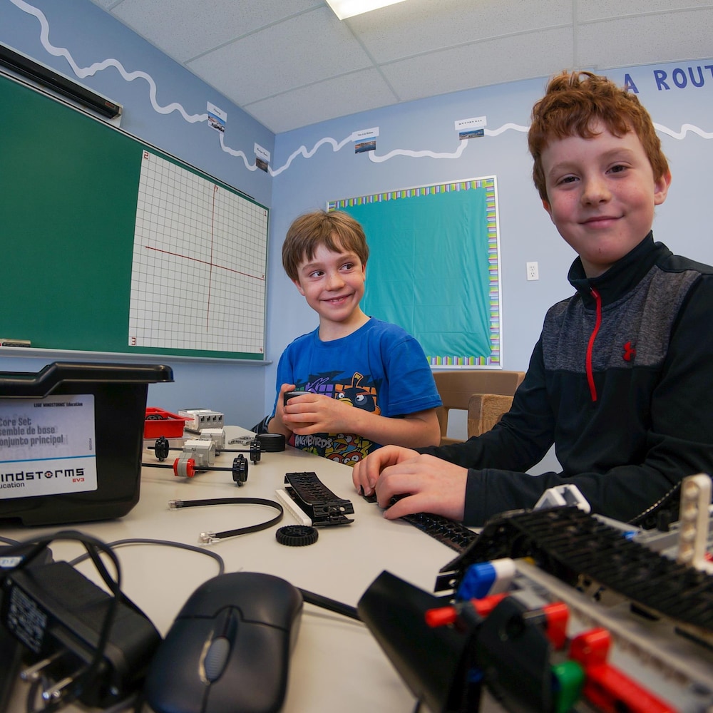 Deux jeunes garçons fabriquent un robot.
