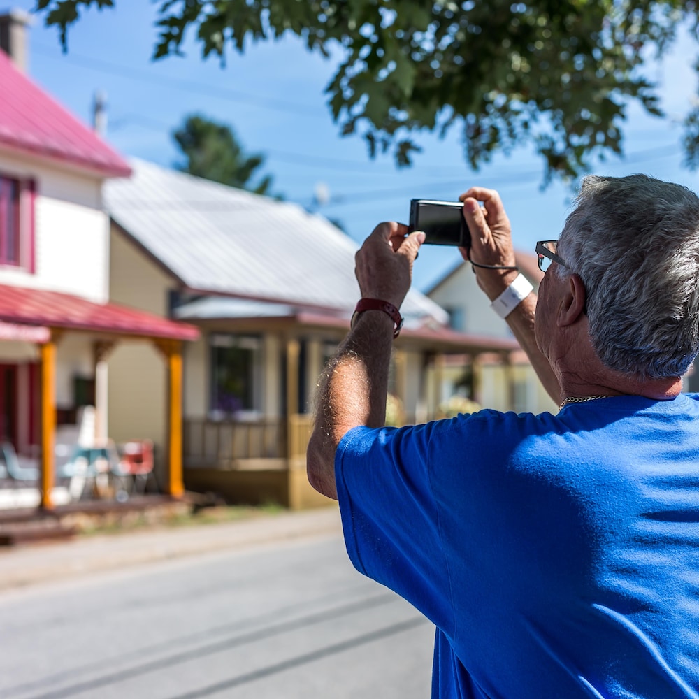 Un homme prend une photo du village de Saint-Élie-de-Caxton.