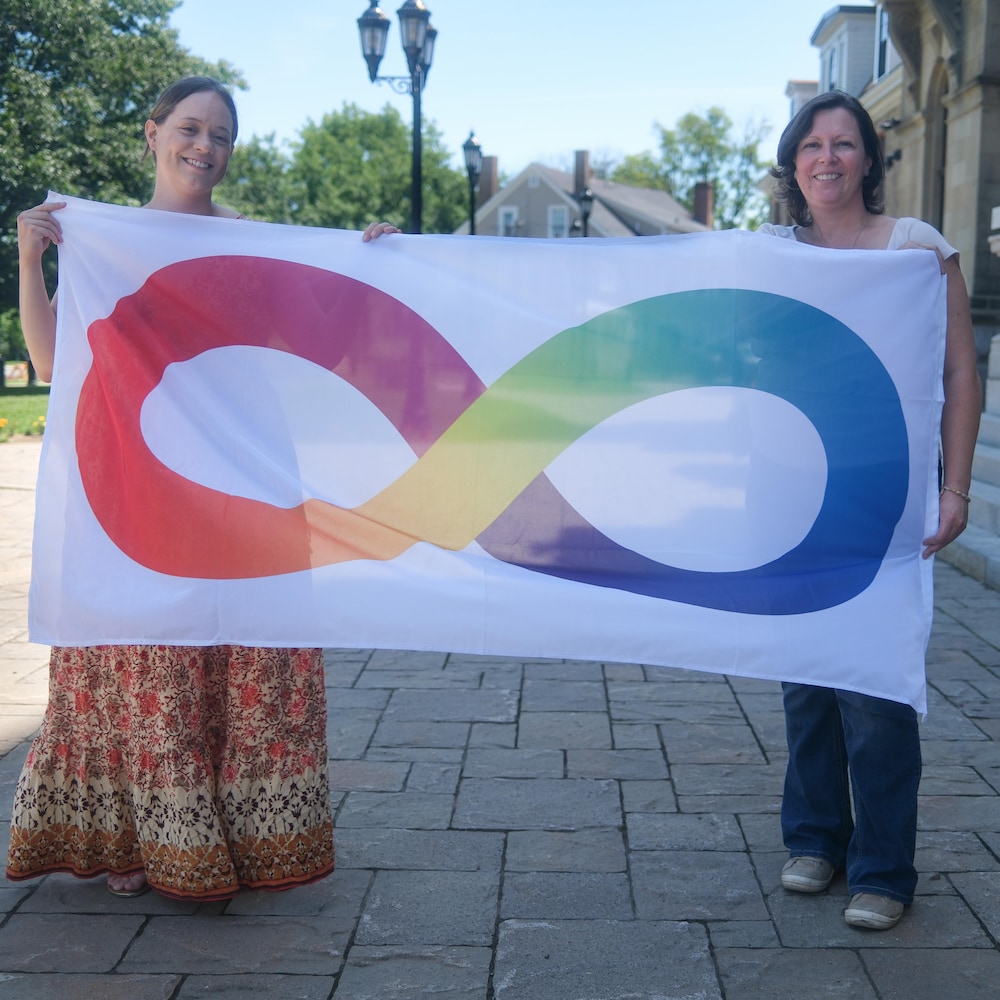 Louise et Caroline tiennent le drapeau de la neurodiversité.