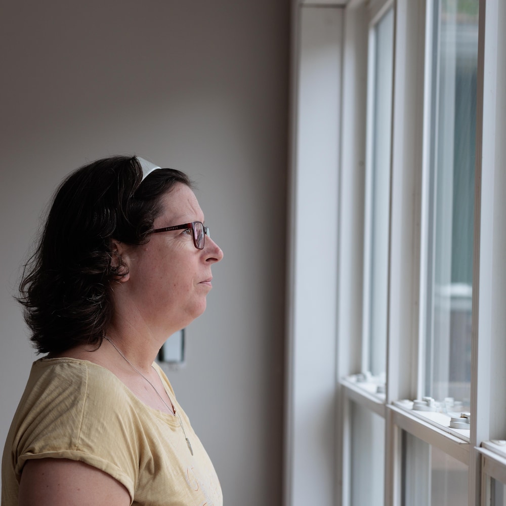 Caroline regarde par une fenêtre.