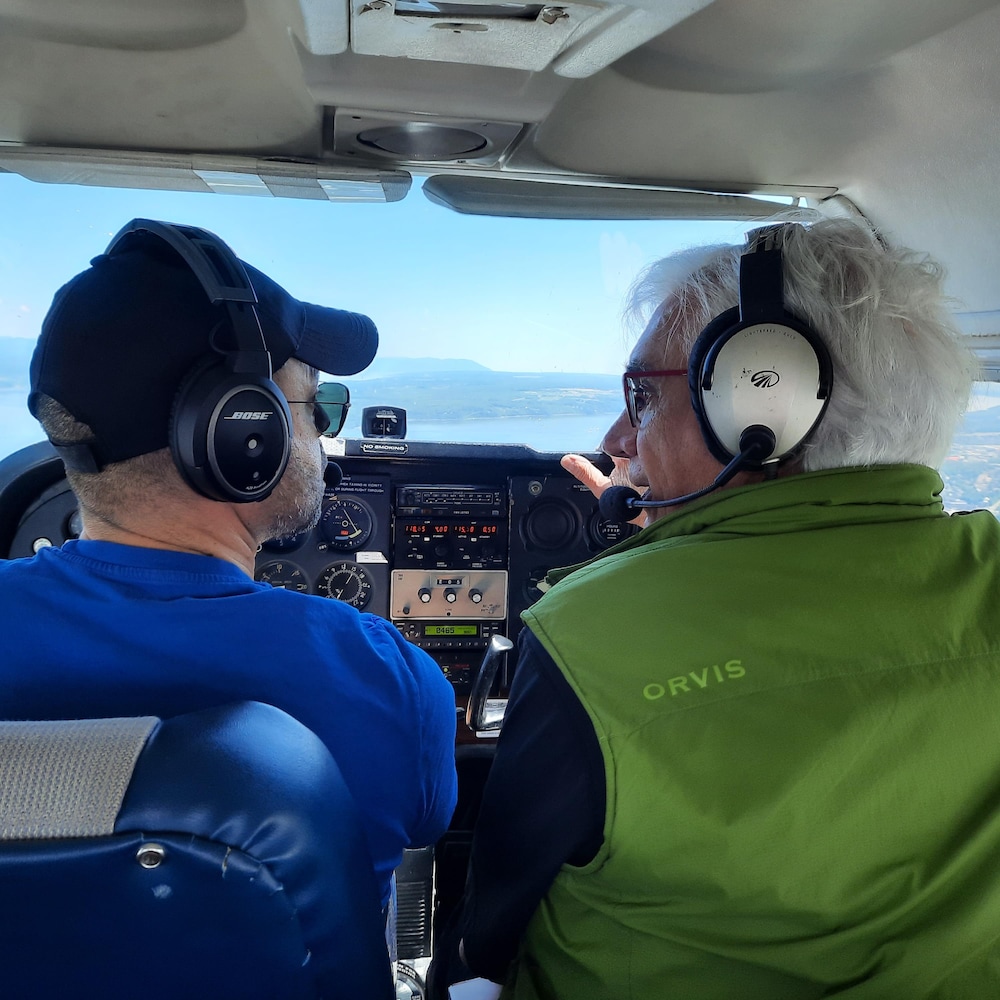 Un pilote d'avion est en discussion avec un photographe alors qu'ils sont en vol.