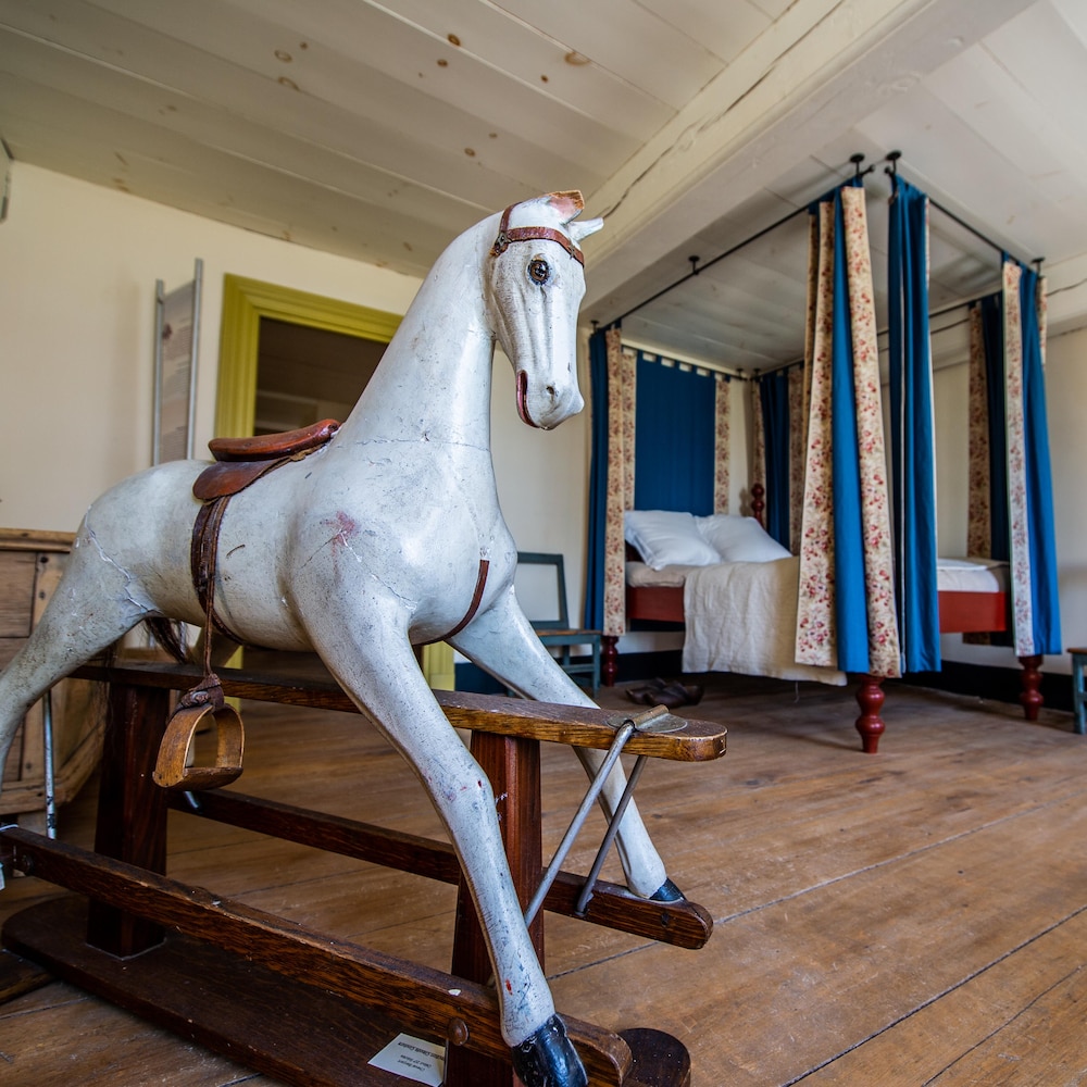 Un cheval de bois et un lit à baldaquin dans une chambre d'enfant datant du 18e siècle.