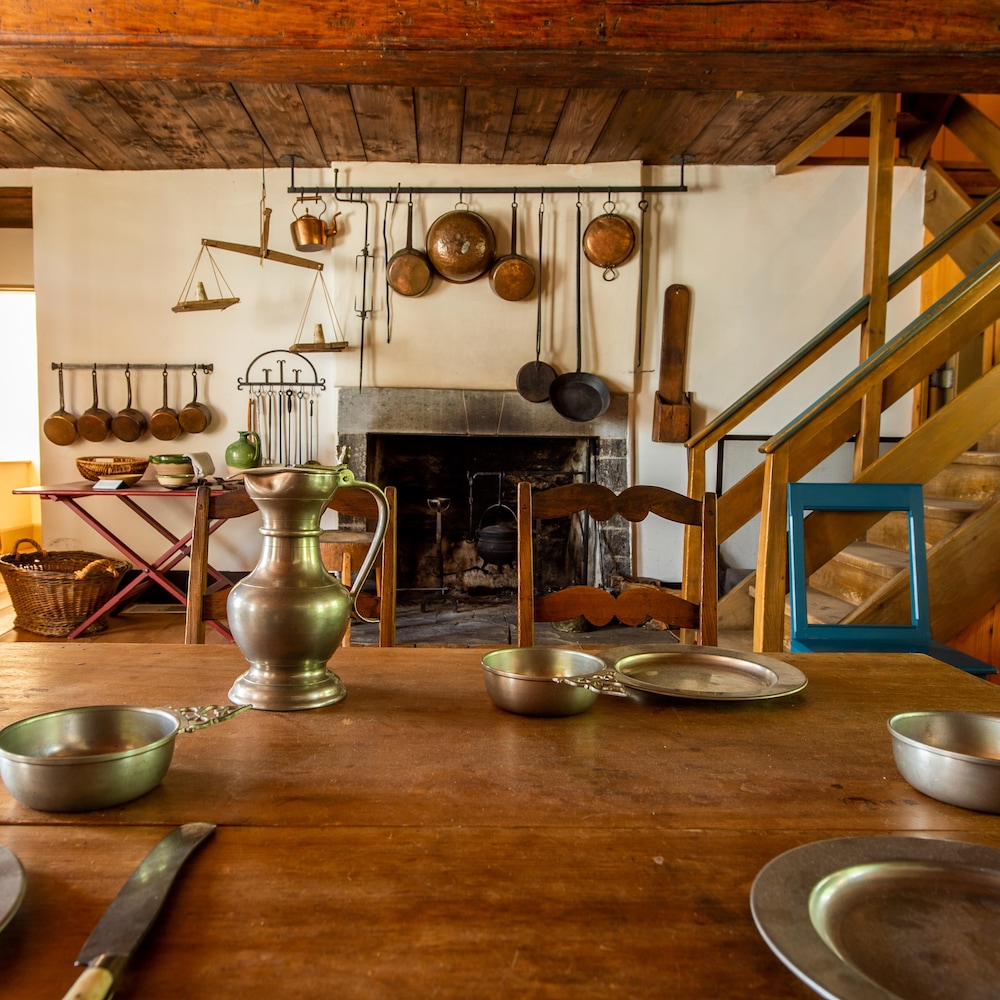 Des éléments de cuisine en métal dans une cuisine de bois ancienne datant du 18e siècle.