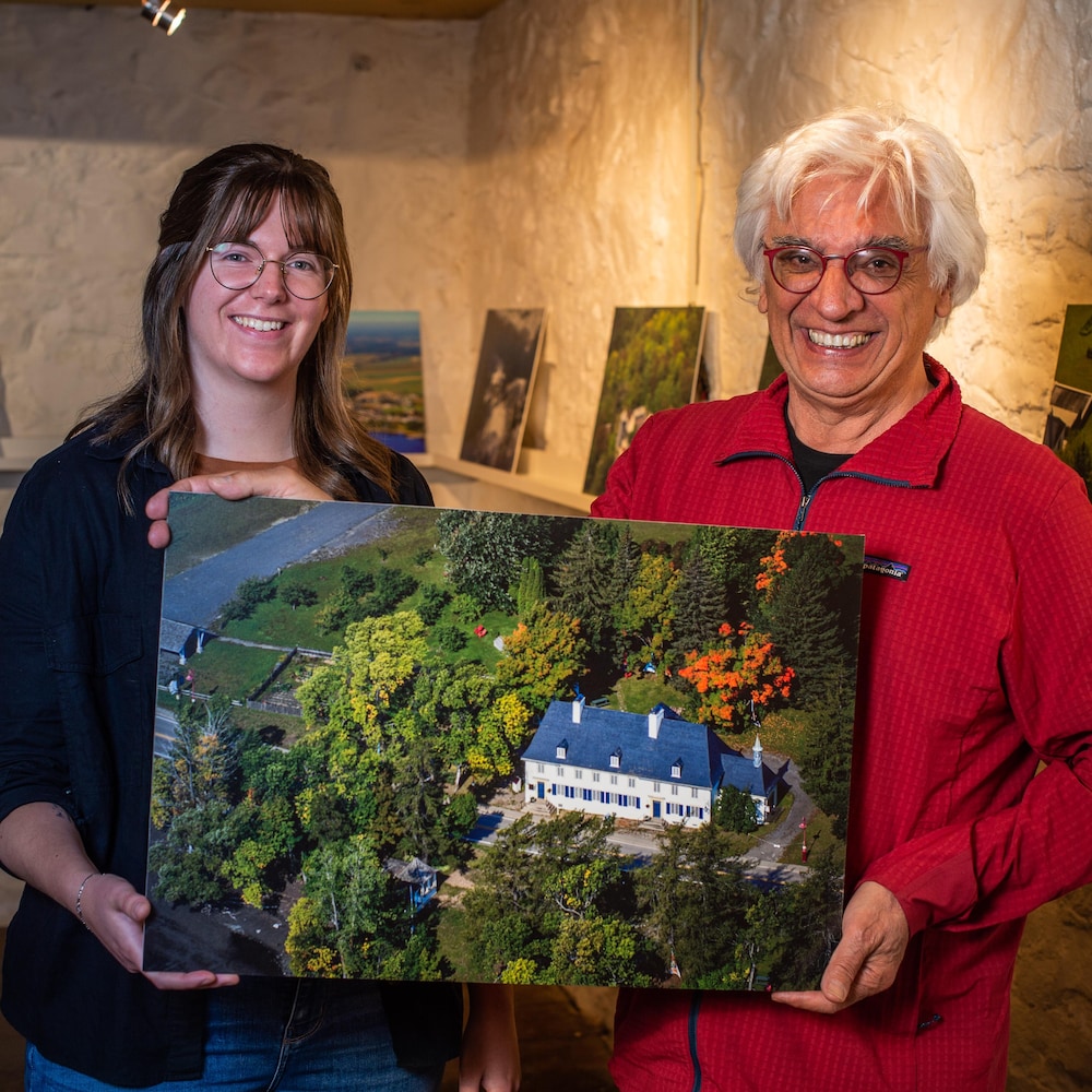 L'historien et photographe Pierre Lahoud pose avec Sarah Thibodeau-Cormier et les deux tiennent une photo imprimée dans leurs mains.