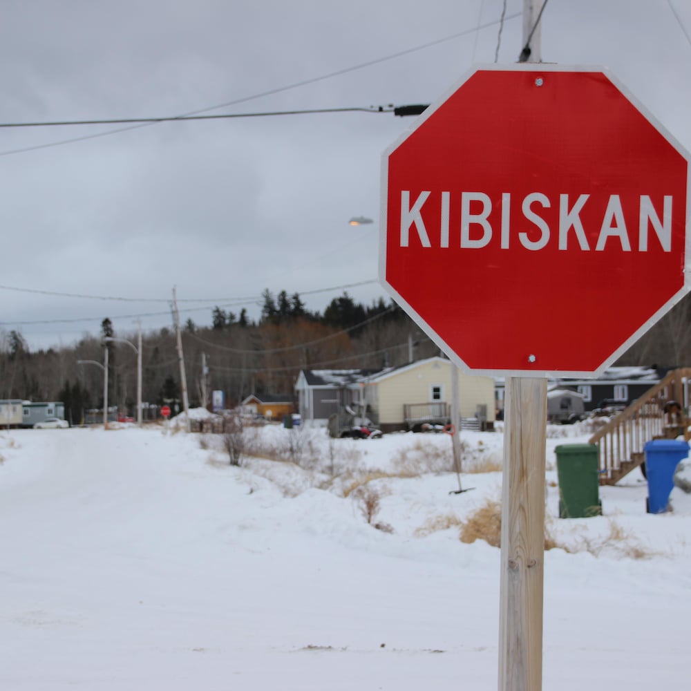 Un panneau de signalisation où il est écrit Kibiskan devant une rue de Winneway.
