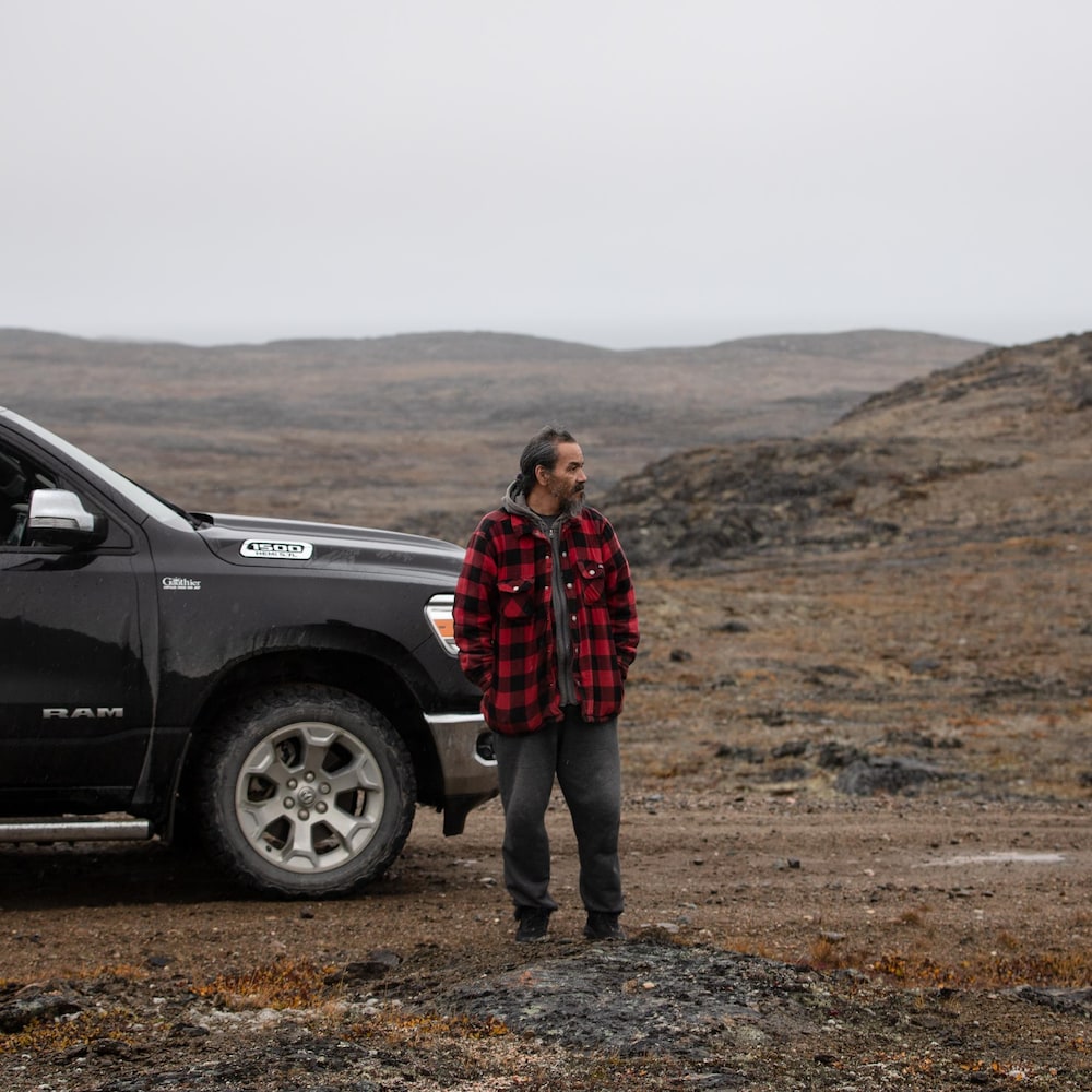 Willie Kaukai se tient debout, devant sa camionnette, stationnée au milieu de nul part dans la toundra.