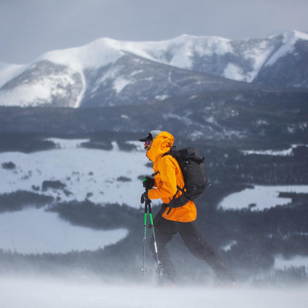 Un skieur alpin devant une chaîne de montagne l'hiver.