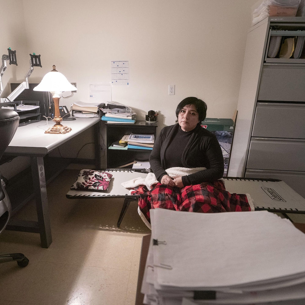 Eugenia Pineiro Cota assise sur un petit lit de camp dans son bureau de travail.