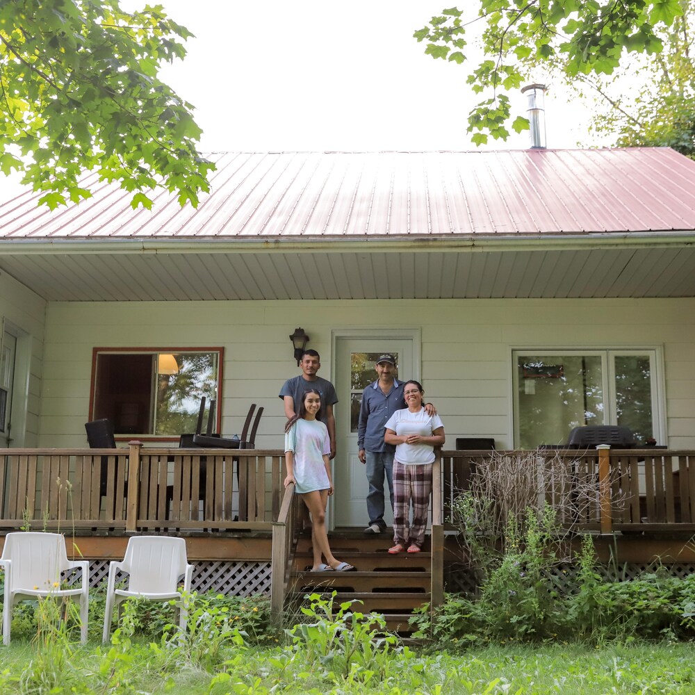 Quatre personnes debout sur le balcon d’un chalet.