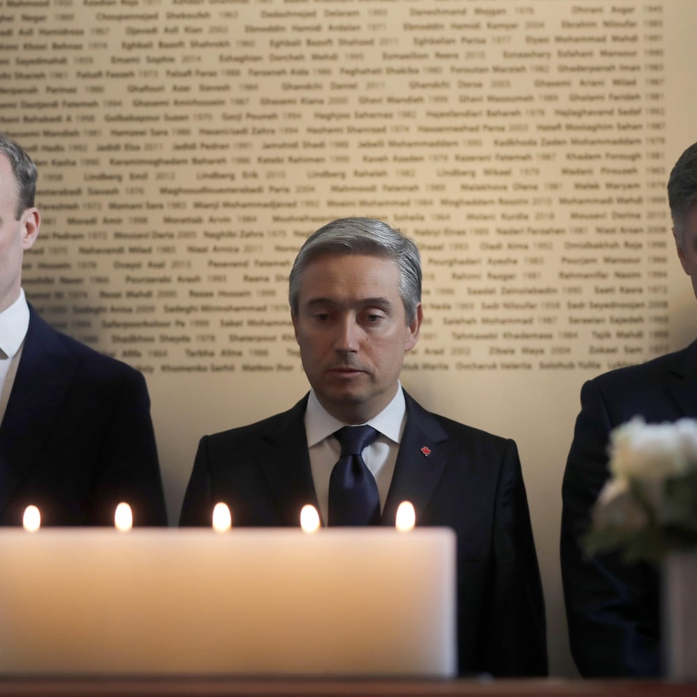 Les trois politiciens devant des chandelles durant une minute de silence au Haut–commissariat du Canada au Royaume–Uni, situé à Londres.