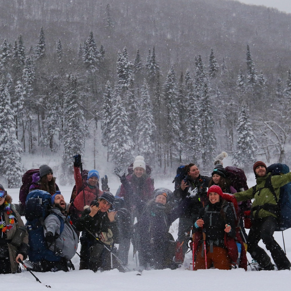 Le groupe prend une pause pour prendre une photo de groupe. Des jeunes ont lancé de la neige en l'air.