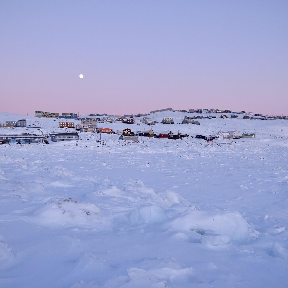 La lune dans un ciel mauve surplombe Iqaluit.