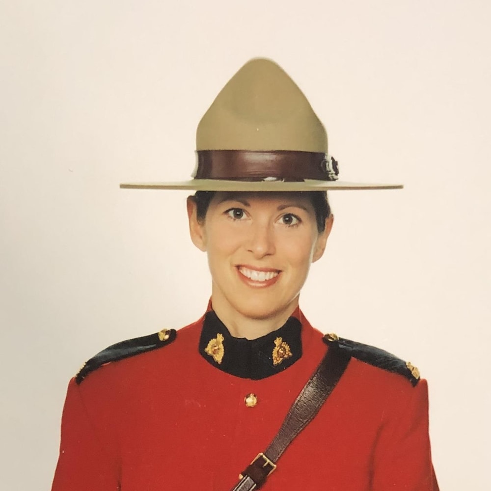 Portrait d'une policière en habit rouge et coiffée du chapeau traditionnel de la GRC.