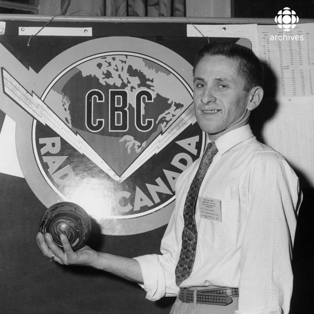 Le joueur de quilles Jean-Guy Rousseau devant le logo CBC/Radio-Canada