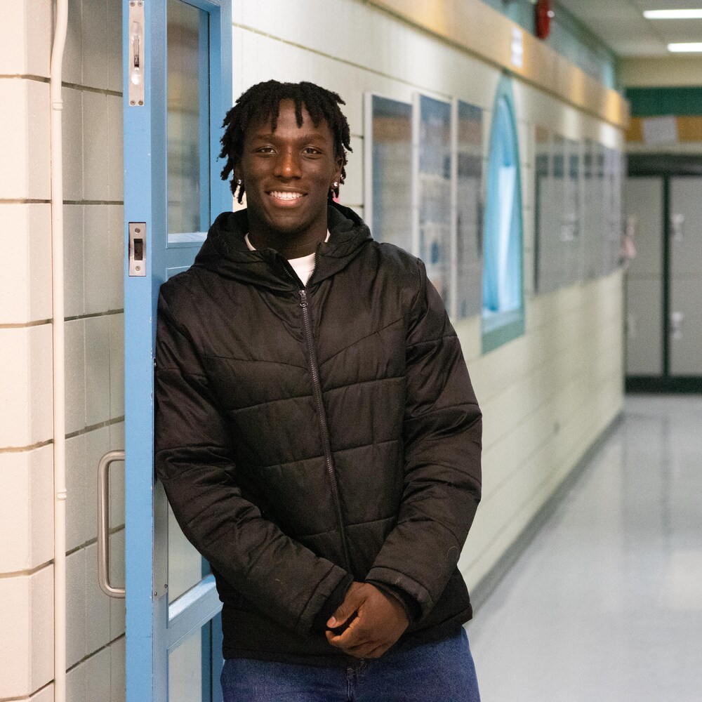 Un jeune homme dans un corridor d'école