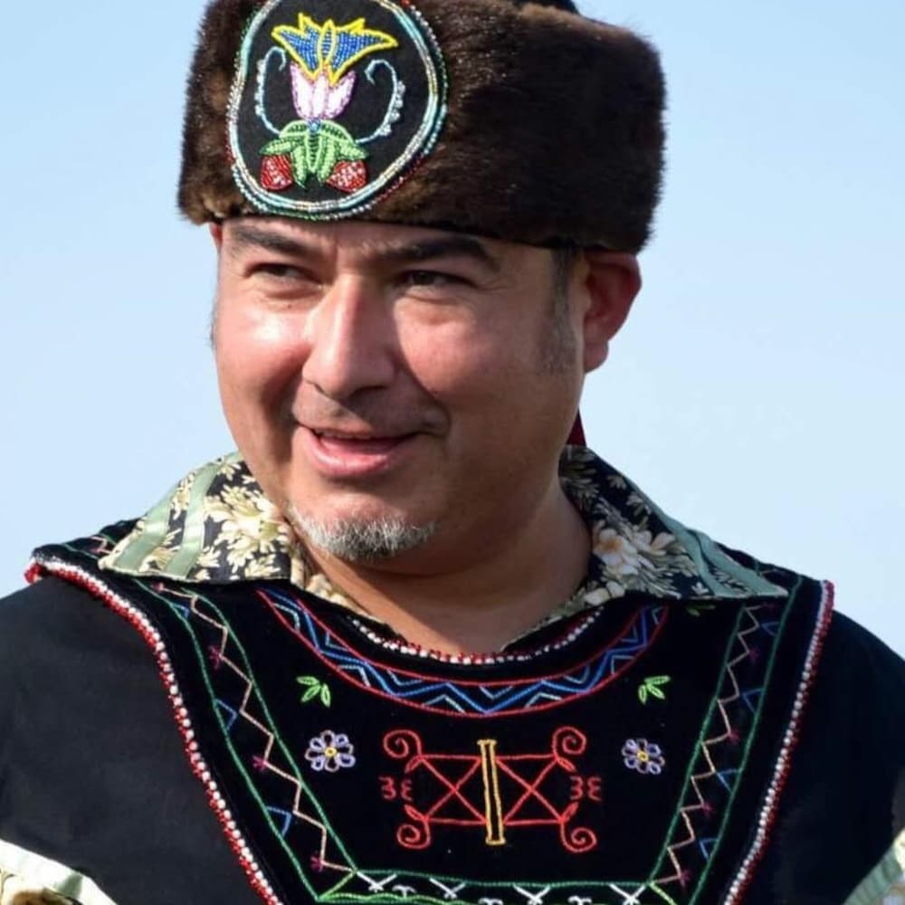 Un homme porte un chapeau traditionnel autochtone.