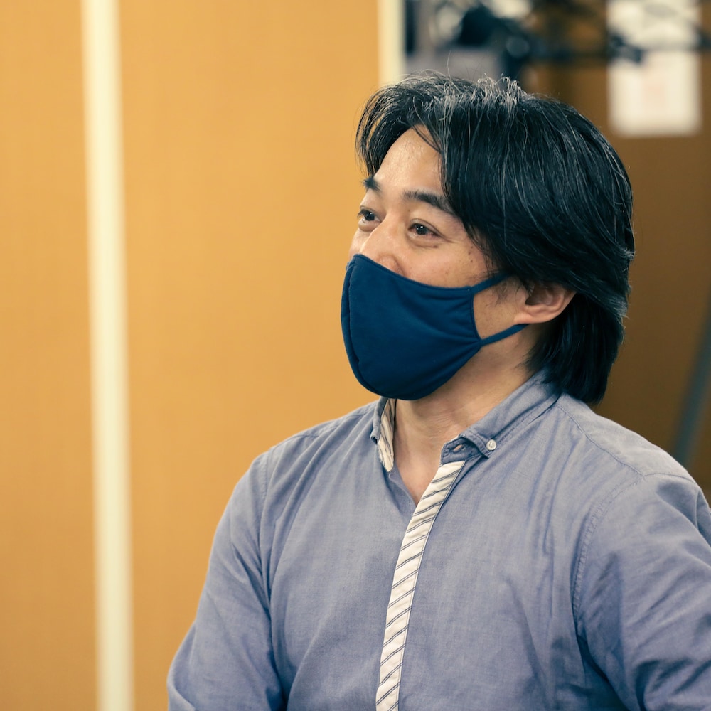 Kenji portant un masque de tissu.