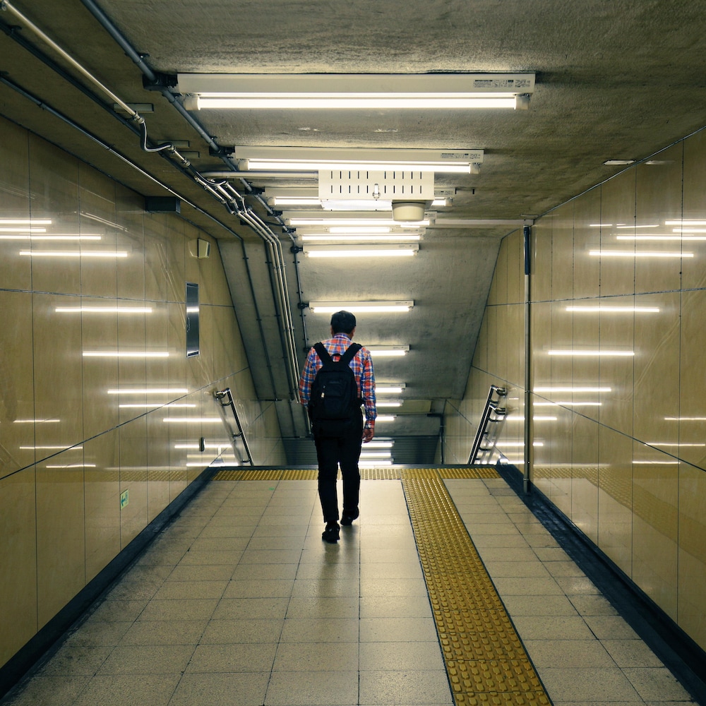 Un homme marche seul dans le métro de Tokyo.