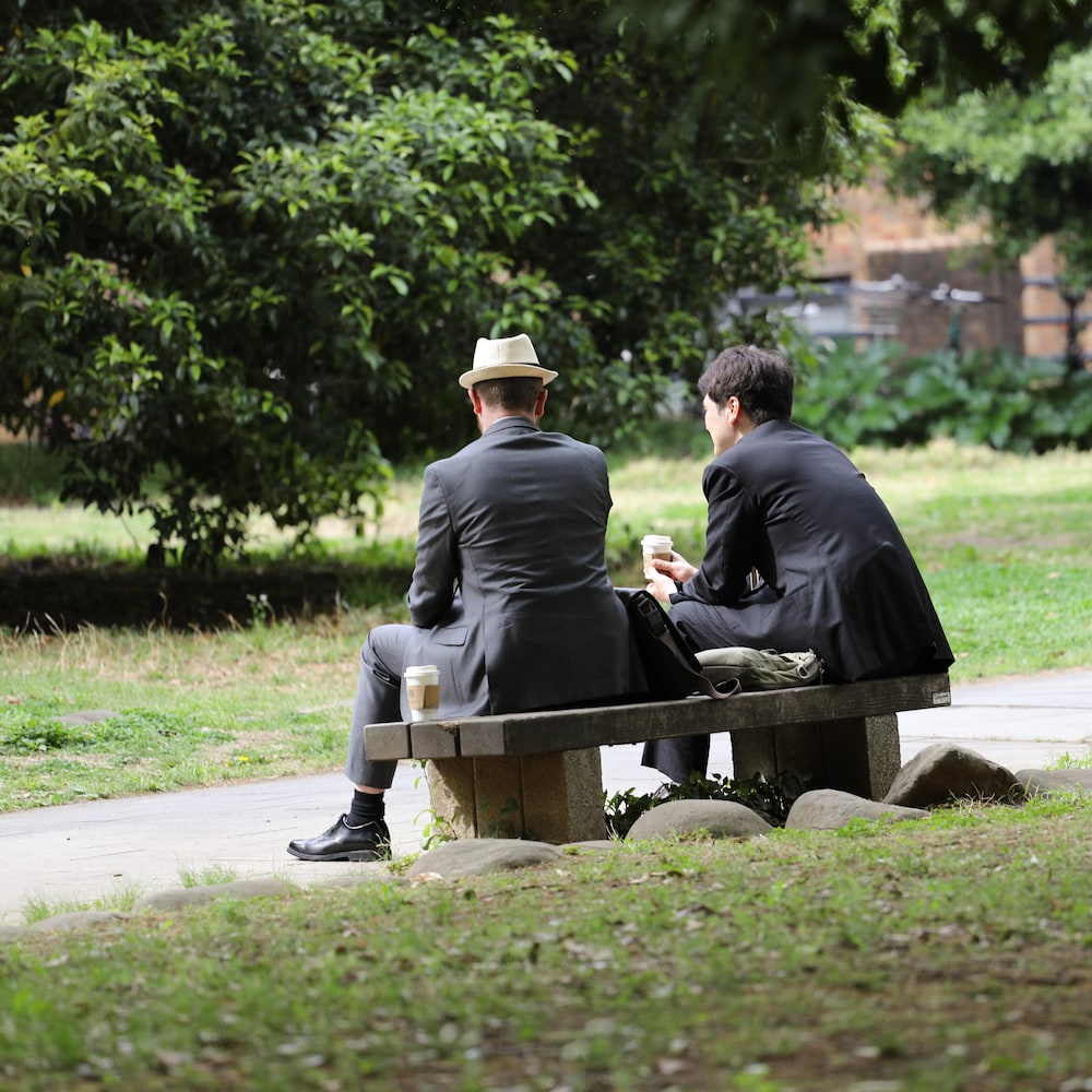 Deux hommes assis sur un banc de parc.