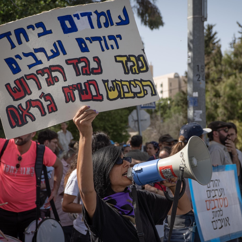 Des Israéliens avec pancarte et porte-voix.
