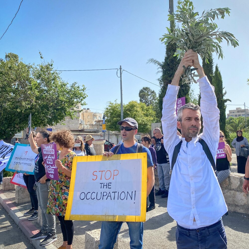 Des Israéliens avec pancarte demandant la fin de l'occupation.