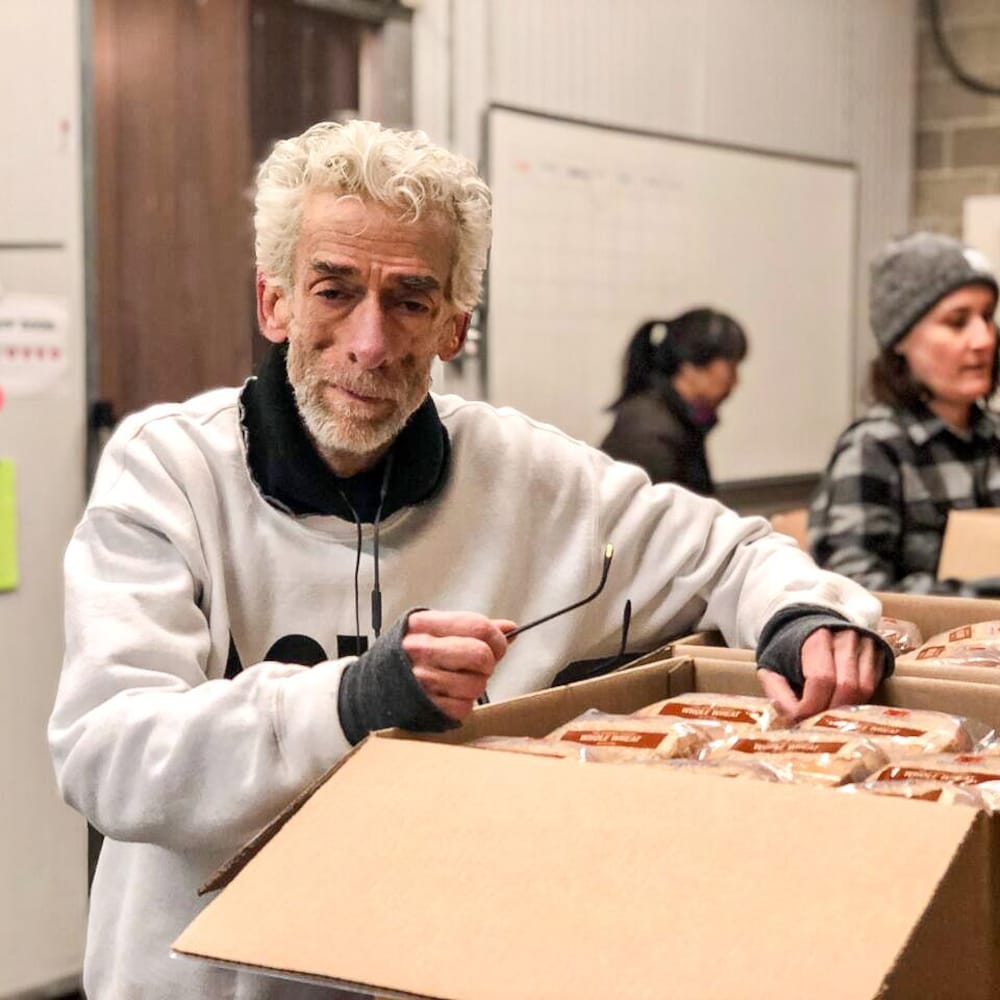 Joe Average s'appuie sur une boîte de nourriture, à Vancouver, en 2019.
