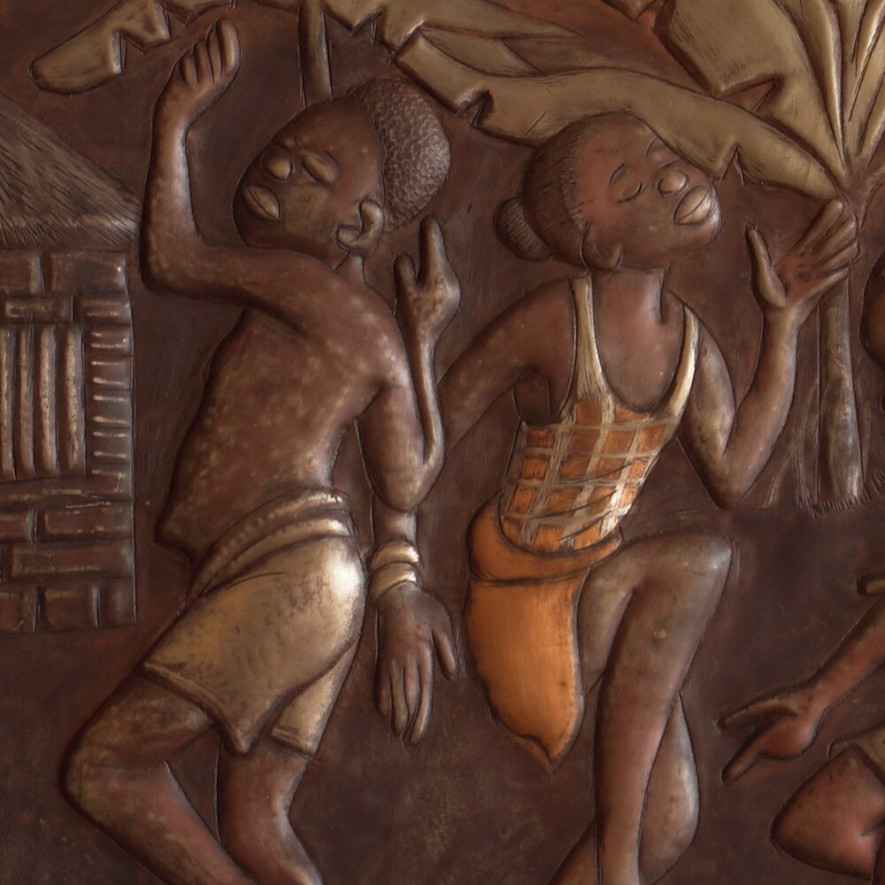 Un tableau en cuivre martelé qui représente des enfants congolais qui dansent devant une hutte.
