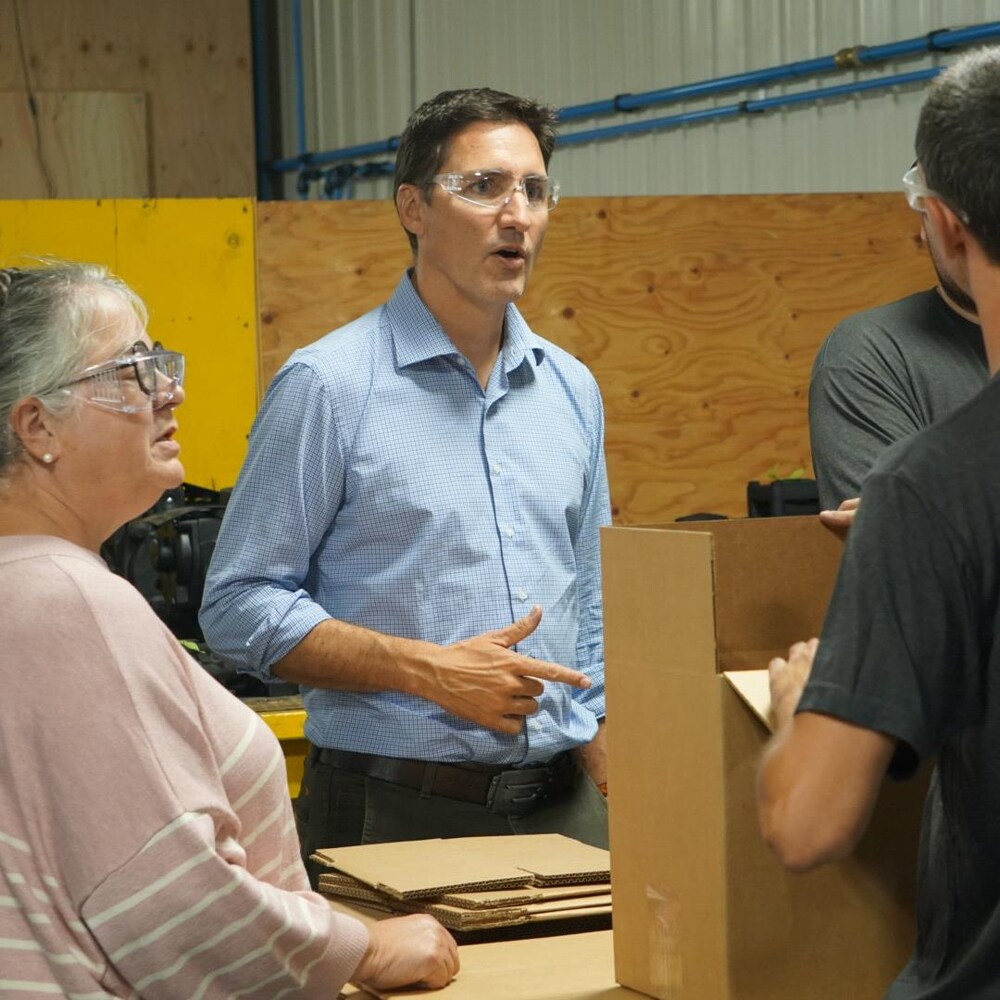 Justin Trudeau et Diane Lebouthillier discutent avec un employé de l'usine.