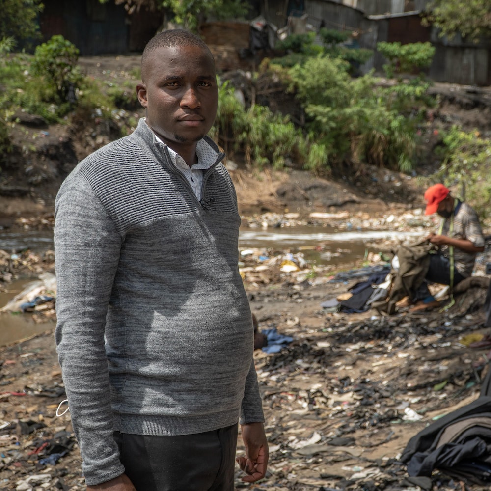 Bernard Mambo sur le bord d'un cours d'eau contaminé.