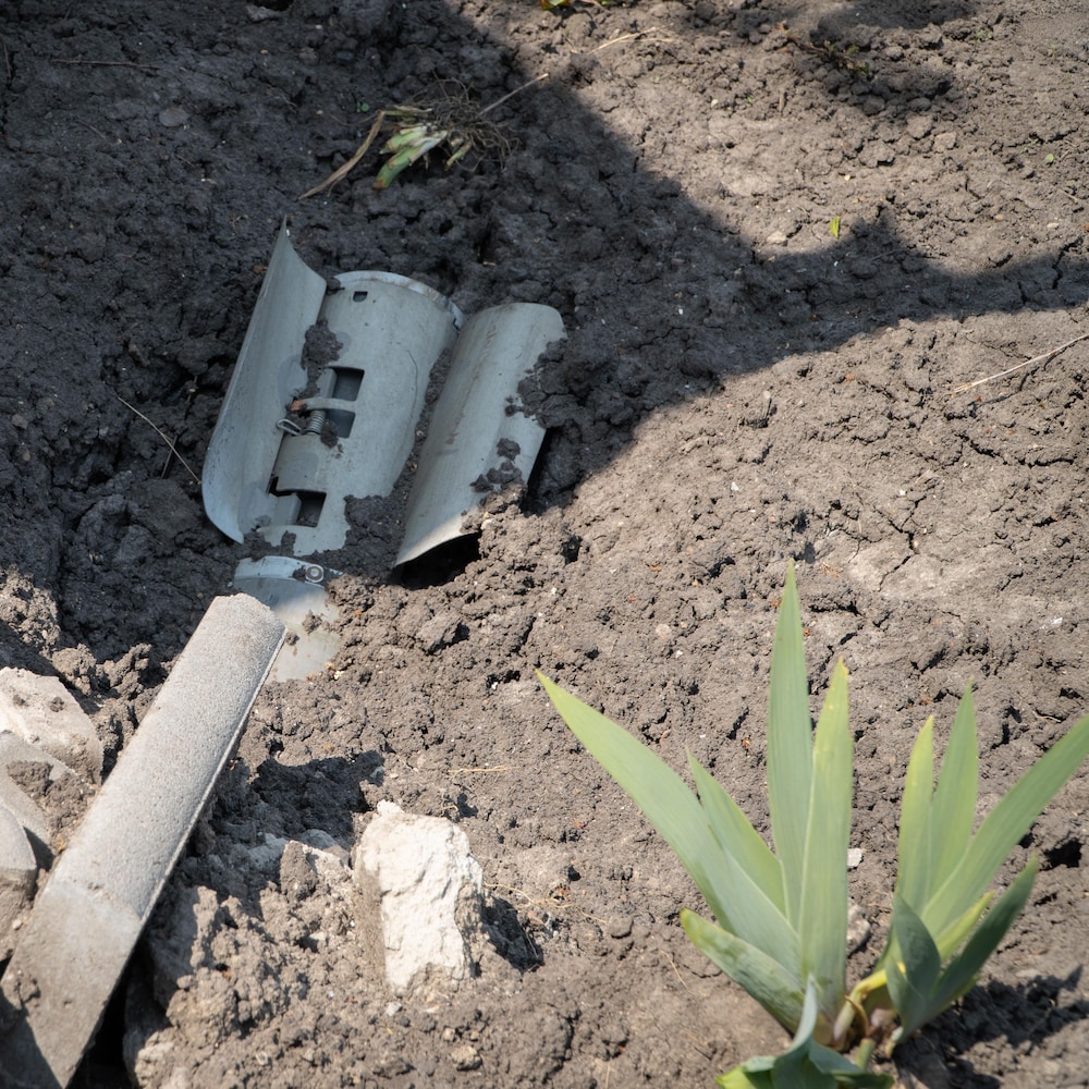 A rocket partially buried in the ground.