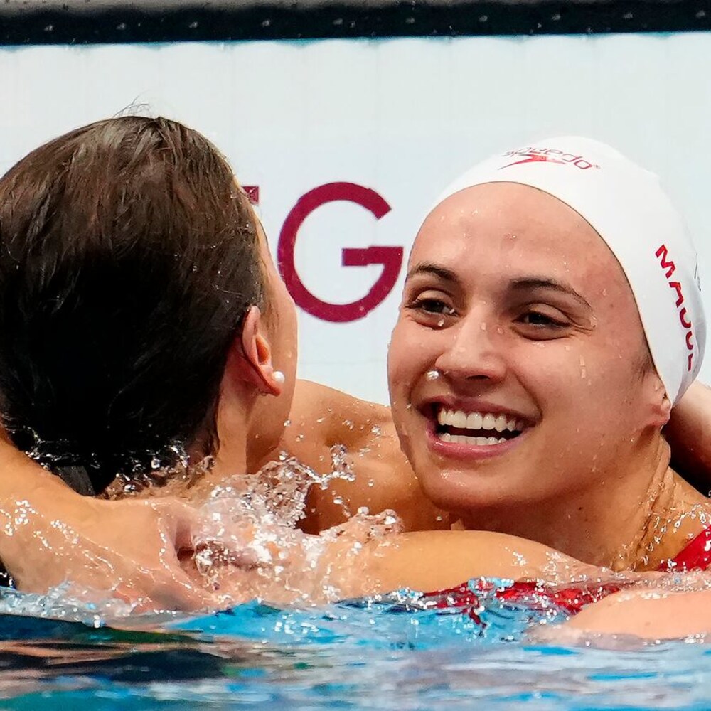 Niyakap ni Kylie Masse si Kaylee McKeown sa swimming pool.