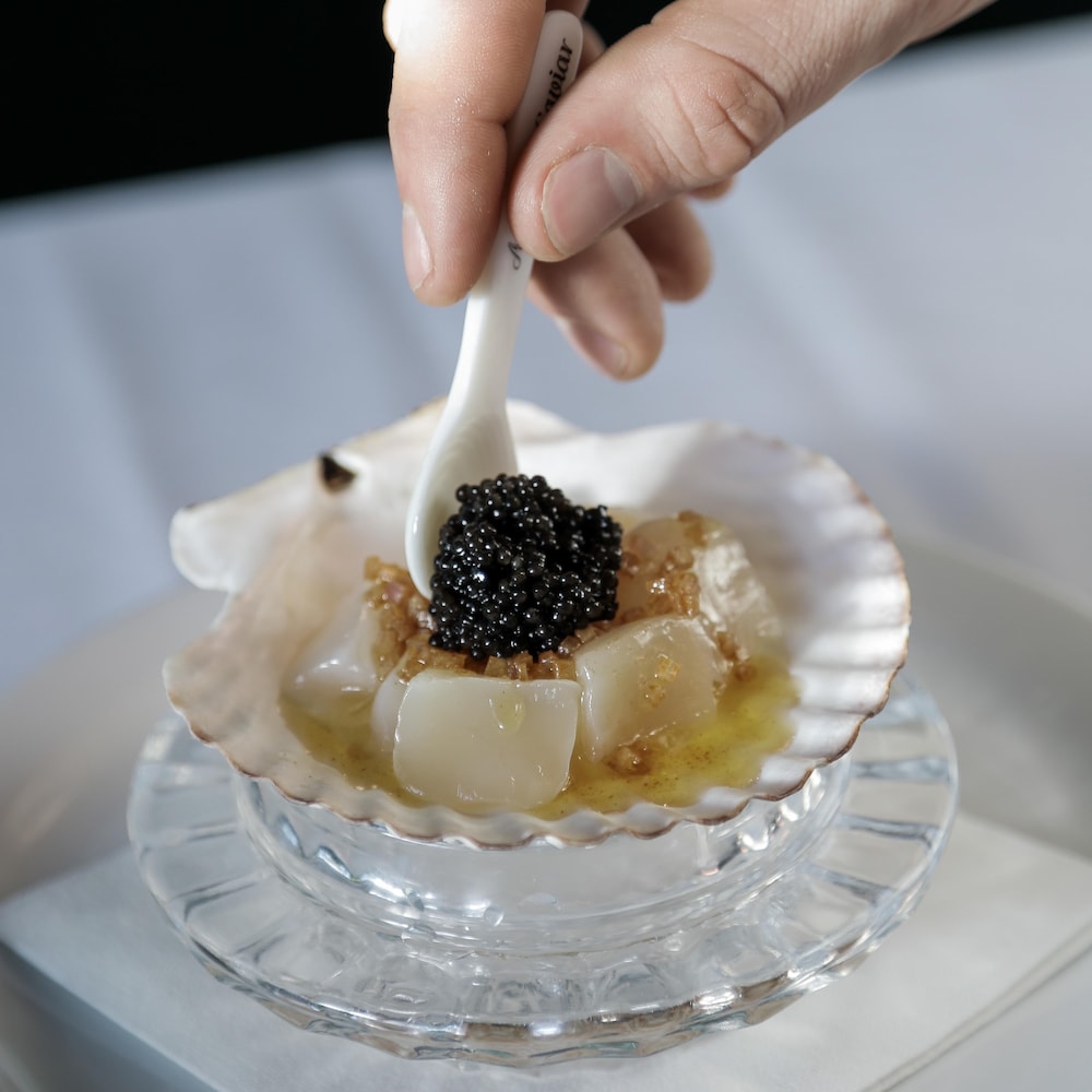 Du caviar servi sur une coquille Saint-Jacques.