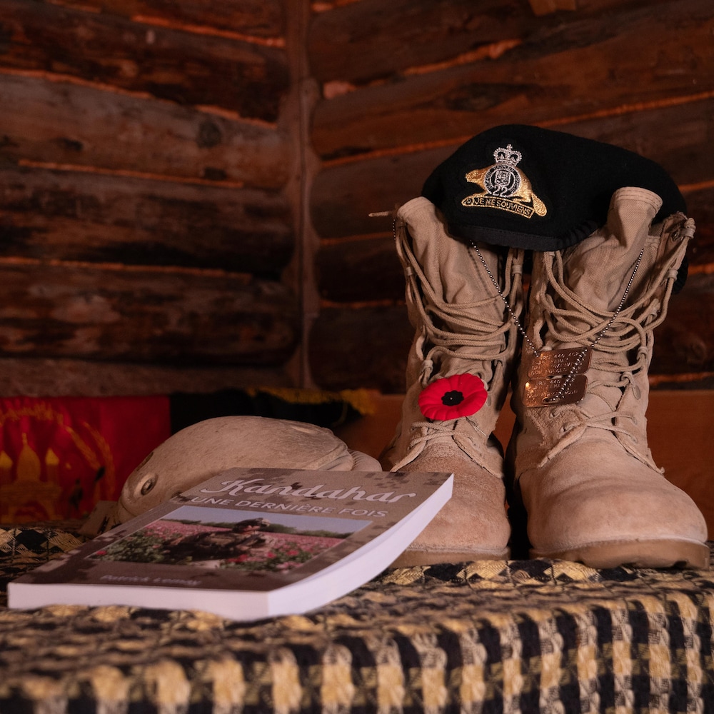 Le livre de Patrick Lemay posé à côté d'une paire de bottes militaires sur un banc.