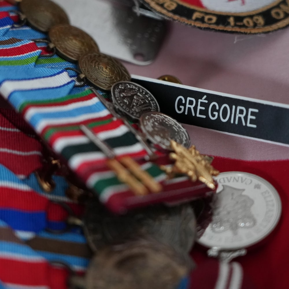 Plan rapproché des médailles et décorations posées sur une table.