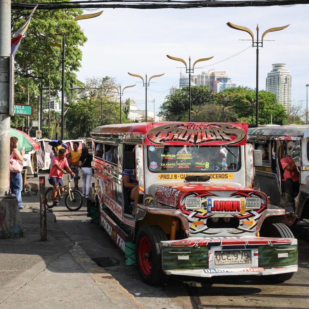 Un bus recouvert de décoration dans une rue avec beaucoup de monde, à Manille, aux Philippines en mai 2025.