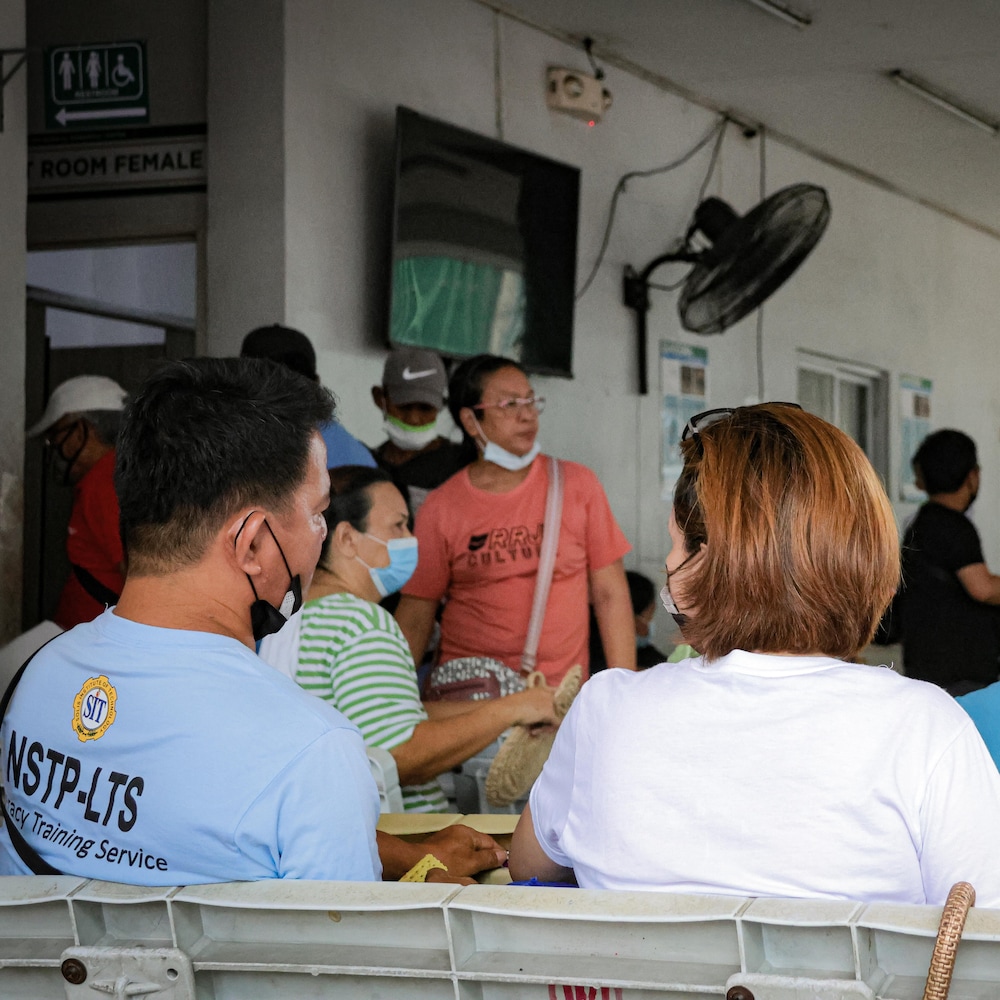 Jocelyn Andamo de dos assise dans une salle des urgences en train de discuter avec quelqu'un, à Manille, aux Philippines, en mai 2025.