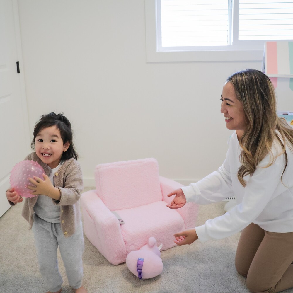 Lhelsey Silapan joue avec sa petite fille dans sa chambre avec des jouets et un petit fauteuil d'enfant, à Calgary, en mai 2025.