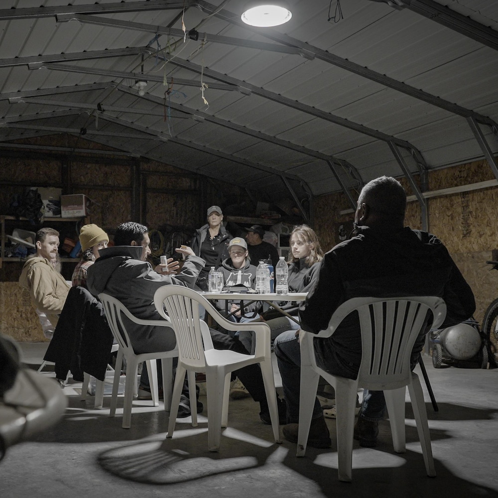 Des personnes réunies autour d'une table dans un garage ou entrepot, à Boardman, en Orégon aux États-Unis, en avril 2026.